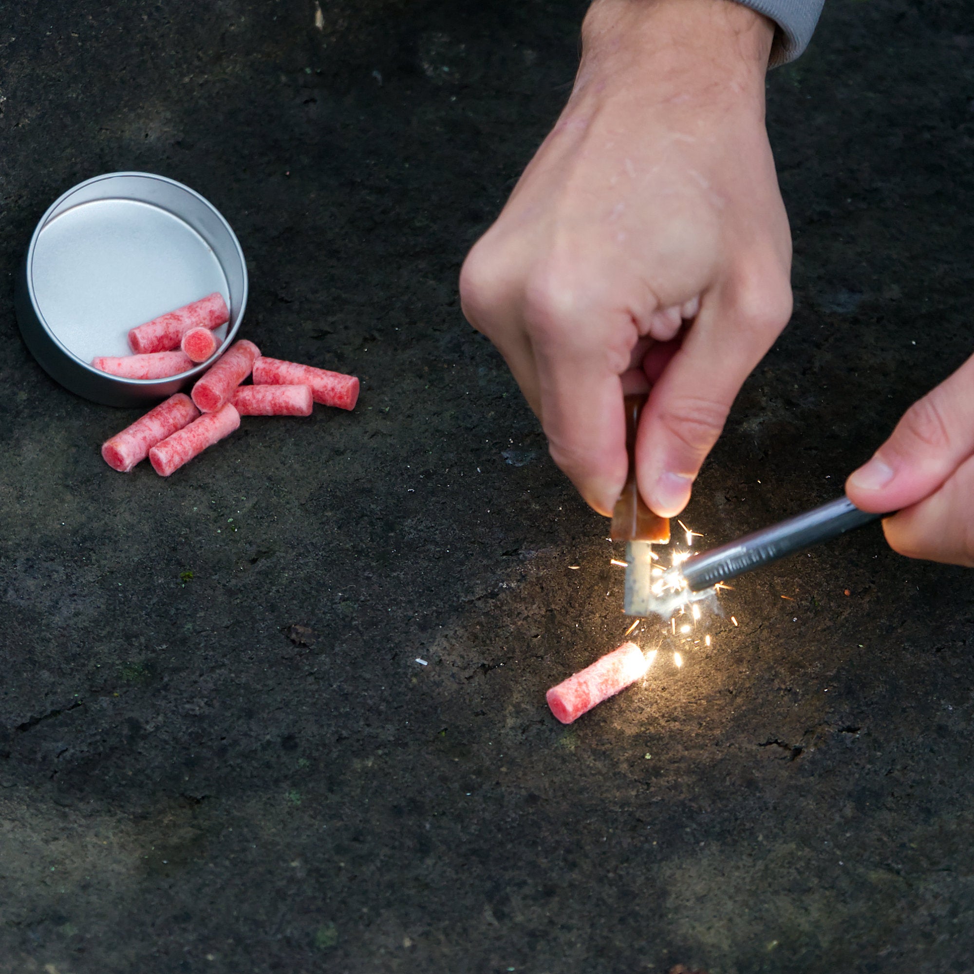 Ensemble allume-feu, comprenant un allume-feu, un grattoir en forme de lame et un allume-barbecue, le tout dans une boîte en acier inoxydable.